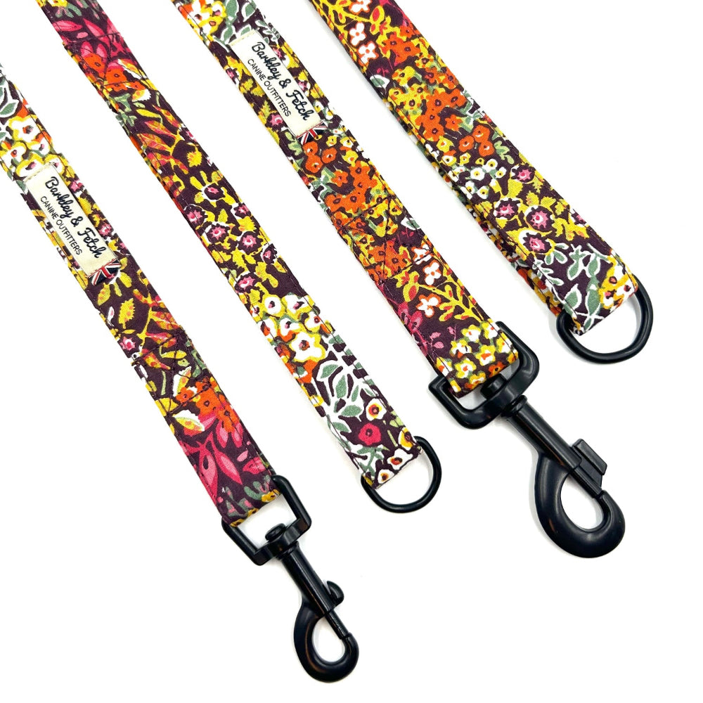 Floral patterned dog leashes with black clips on a white background