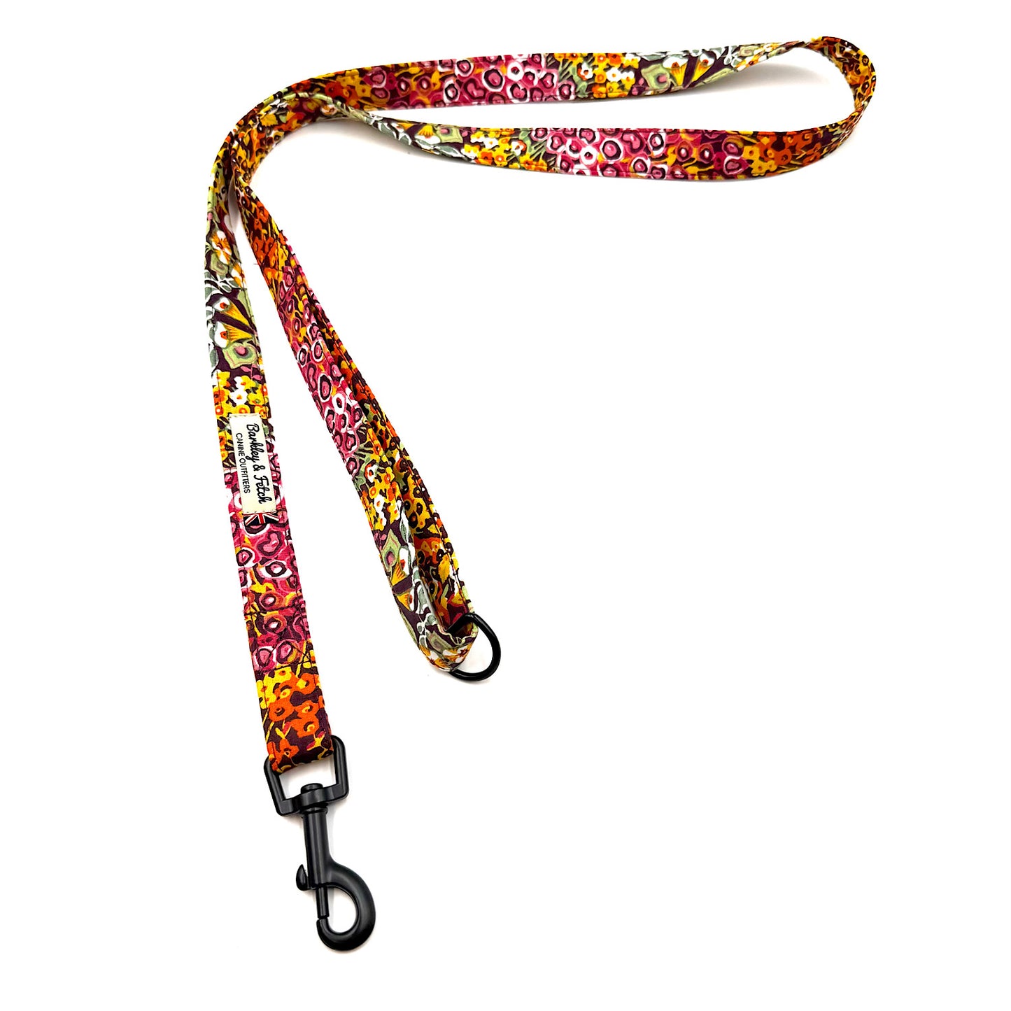 Colorful patterned dog leash with a black clip on a white background