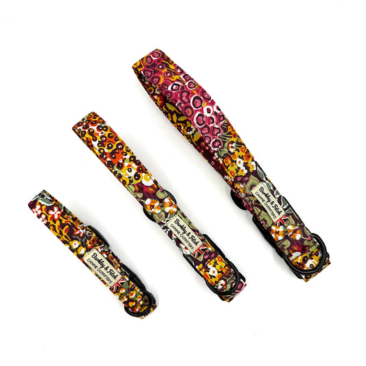 Three colorful dog collars with floral patterns on a white background