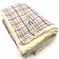 A pale pink tartan dog blanket with a soft white fluffy edge, displaying the brand name 'Barkley & Fetch'.