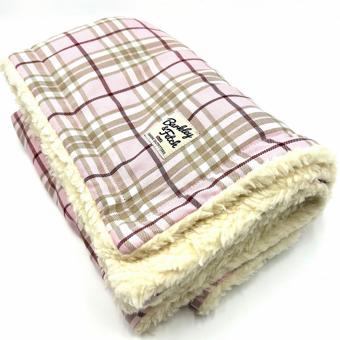 A pale pink tartan dog blanket with a soft white fluffy edge, displaying the brand name 'Barkley & Fetch'.