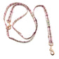 Pink plaid dog leash with gold hardware on a white background