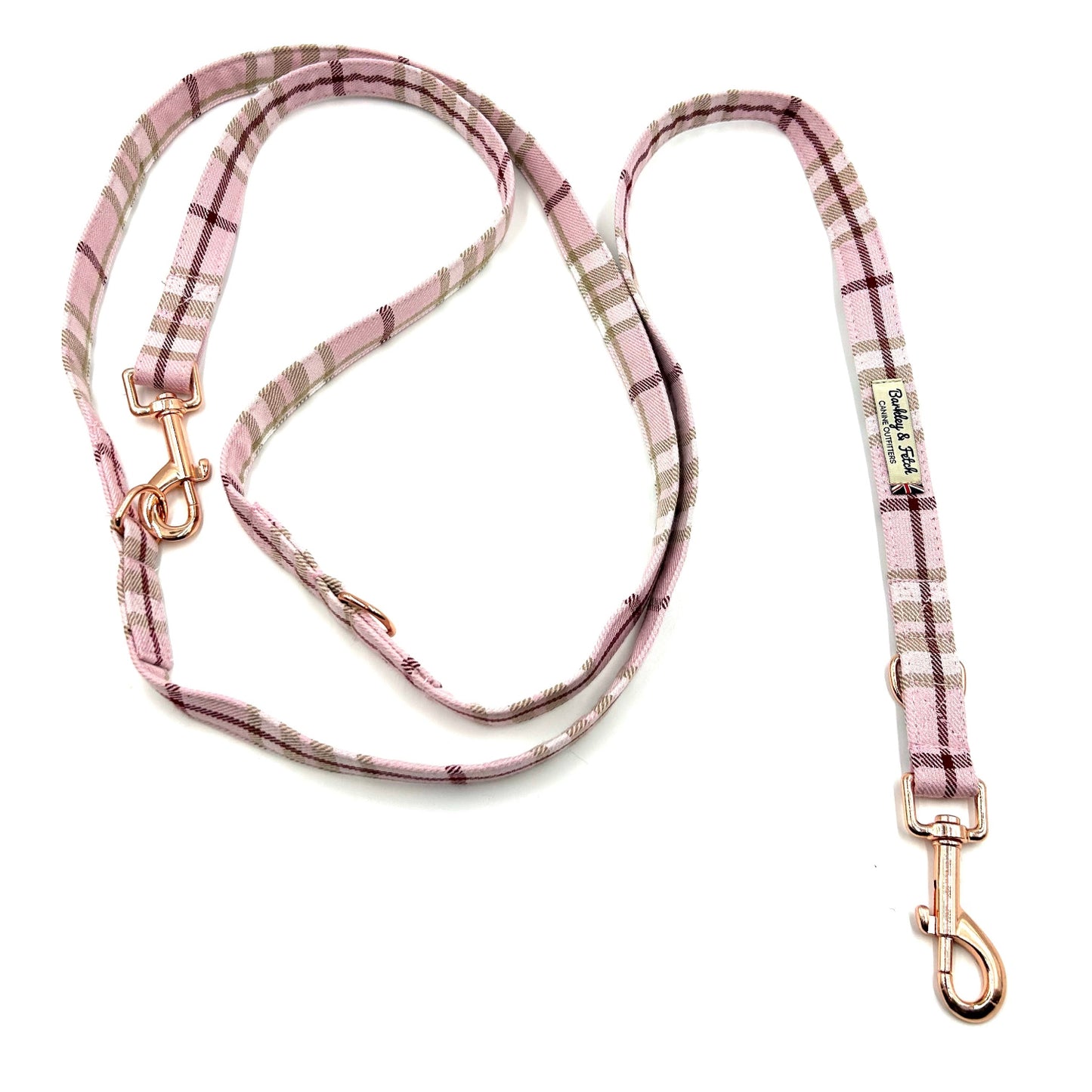 Pink plaid dog leash with gold hardware on a white background