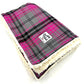 A pink and grey tartan pattern dog blanket with a soft white fleece backing, displaying a branded label on the bottom corner handmade by Barkley and Fetch of Great Britain