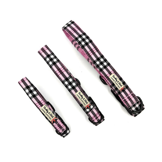 Three pink and black checkered dog collars on a white background