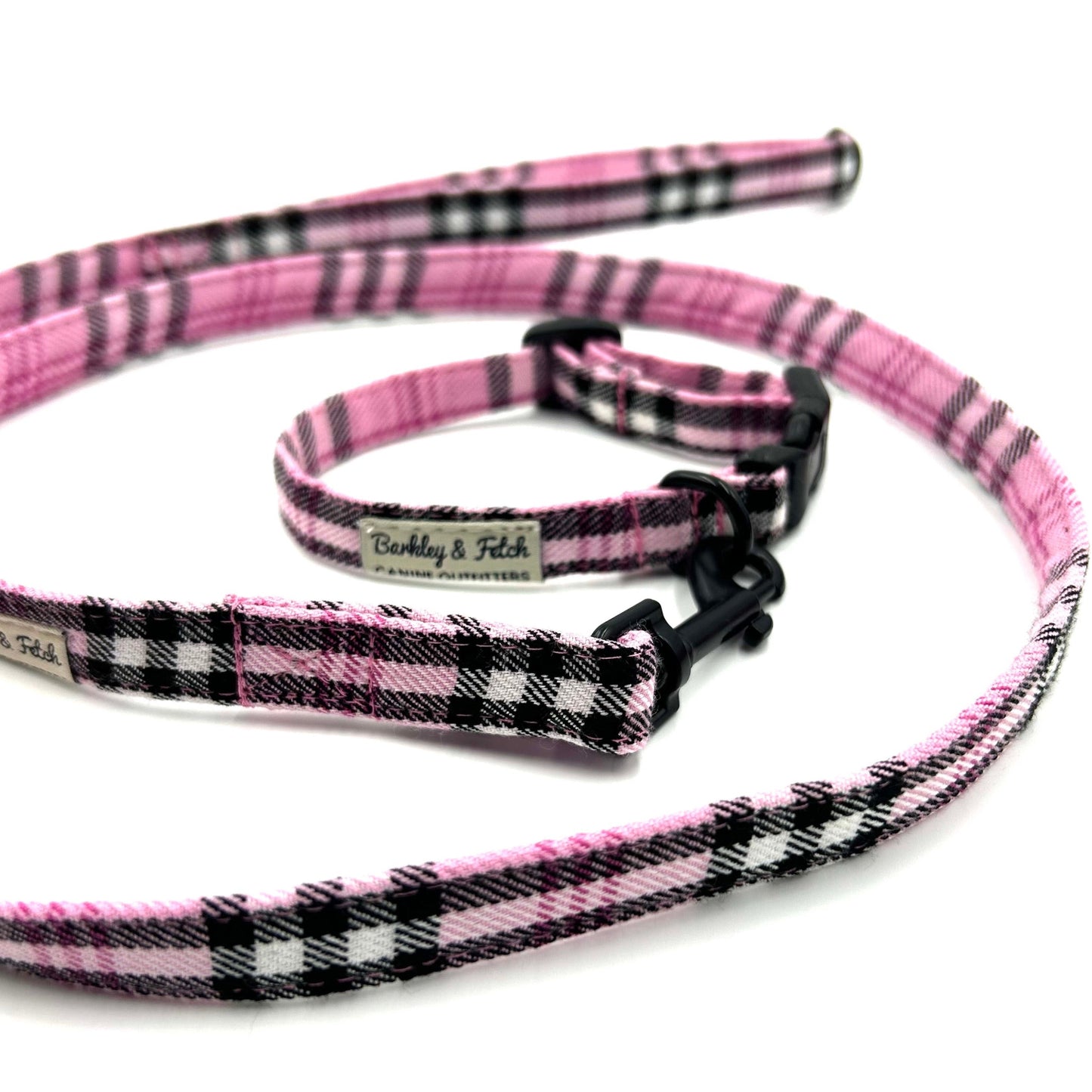 Pink and black plaid dog collar and leash set on a white background
