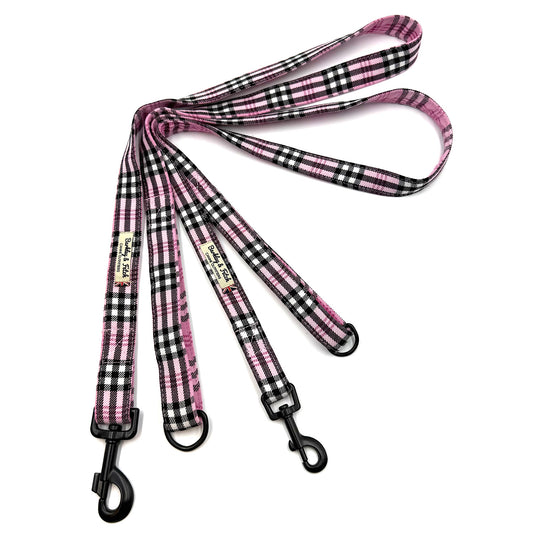 Pink and black checkered dog leash with metal clip on a white background