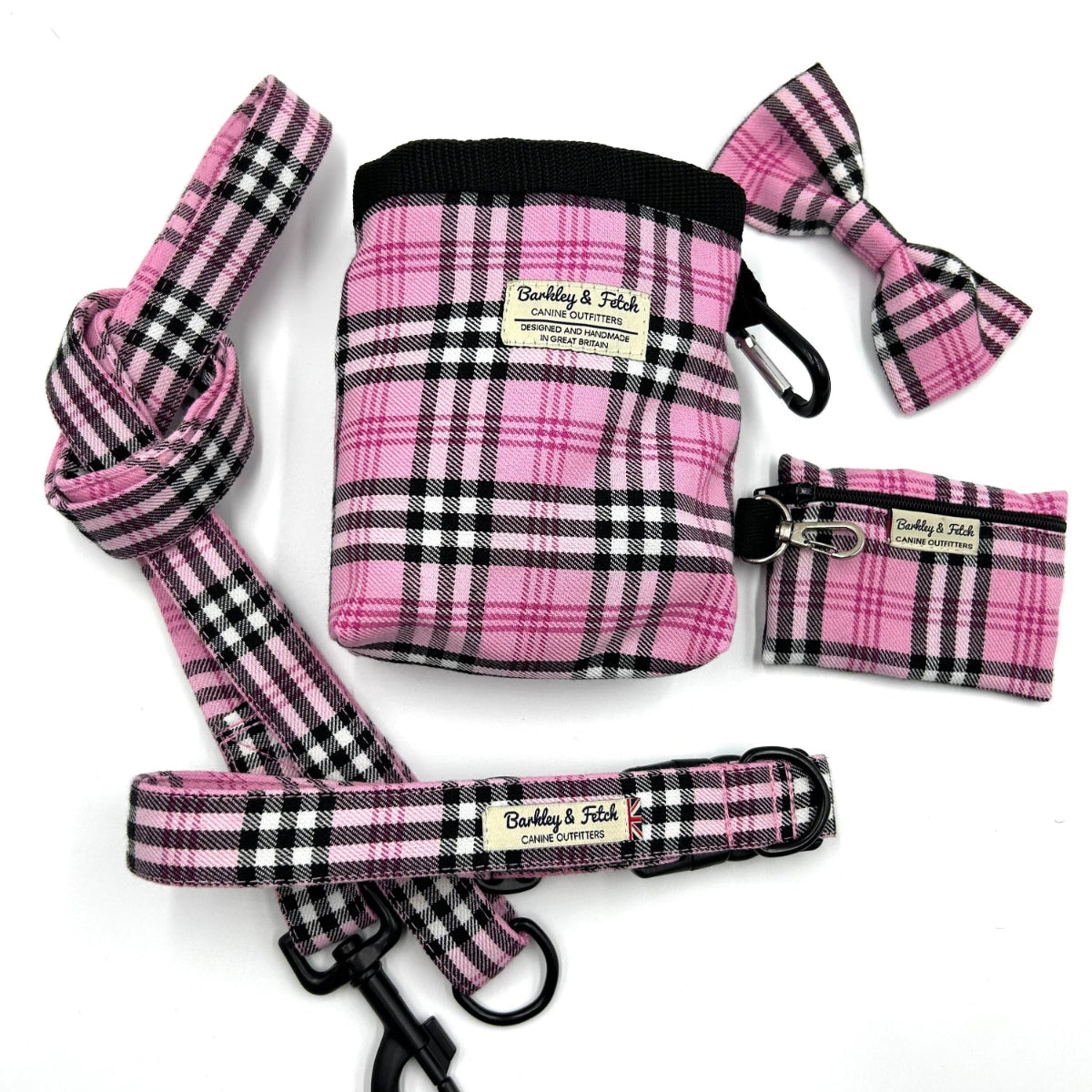 Pink plaid pet accessory set including a bag, leash, and bow tie on a white background.