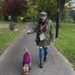 woman walking her dog collecting poo and placing it in the bin