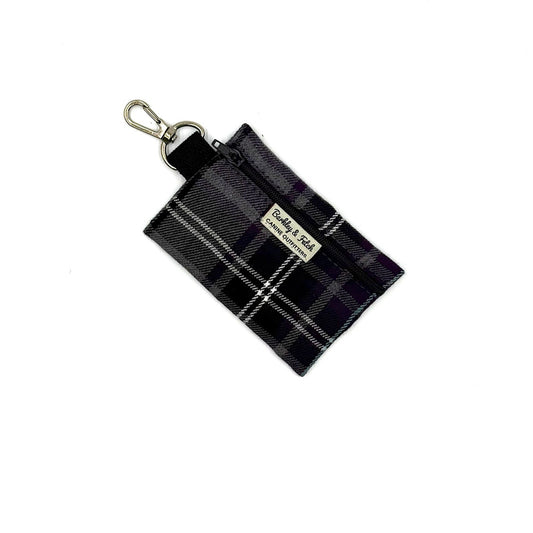 Black and white plaid keychain pouch with a visible brand label on a white background