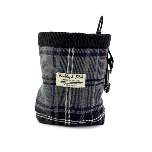 A purple and grey tartan dog treat bag with an elasticated drawcord closure and a brand label displayed on the front.