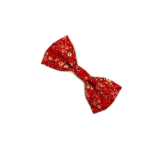 Red bow tie with gold patterns on a white background