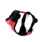 Dog harness with red floral pattern and black straps on a white background