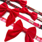 Dog collars with red bow ties and plaid patterns handmade by Barkley And Fetch on a white background