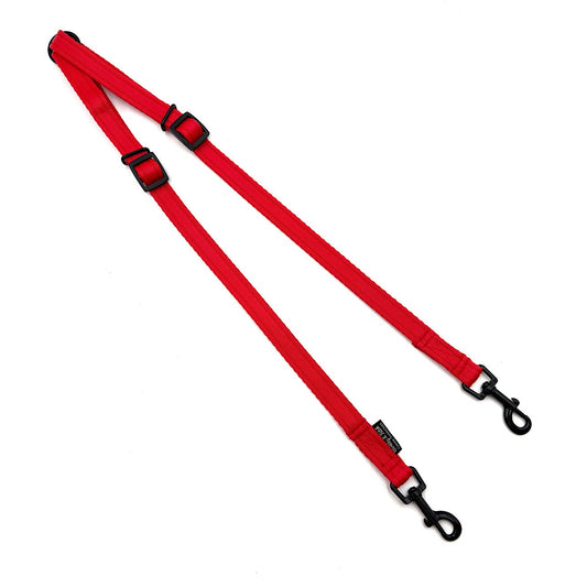 Red dog leash with black clips on a white background