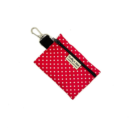 Red polka dot pouch with black zipper and keychain clip on a white background