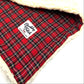 Red plaid blanket with a white label on a white background handmade by Barkley and Fetch of Great Britain