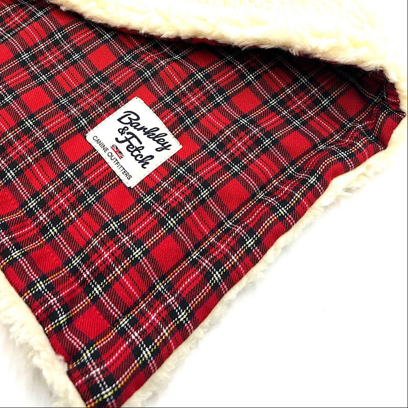 Red plaid blanket with a white label on a white background handmade by Barkley and Fetch of Great Britain
