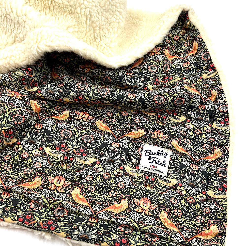 Floral-patterned blanket with fox design and a visible brand label, featuring soft beige fleece on top. handmade in UK by Barkley And Fetch