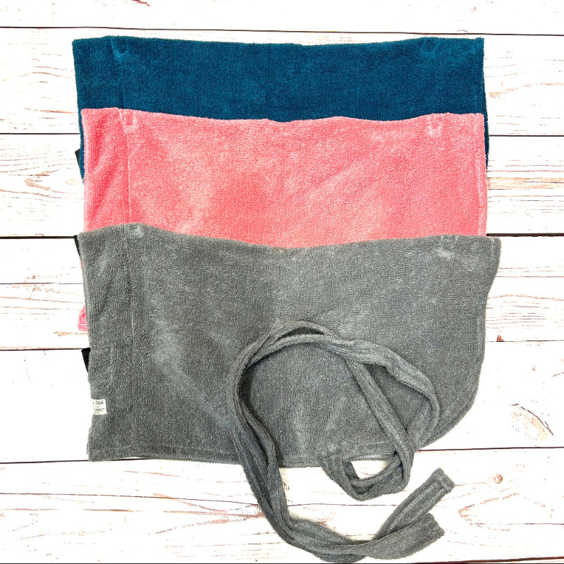 Stack of folded dog towels in blue, pink, and gray on a wooden surface handmade by Barkley and Fetch UK