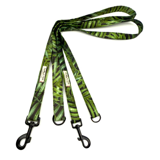 Green leaf-patterned dog leash with black clip on a white background