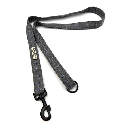 Gray checkered dog leash with a metal clip on a white background