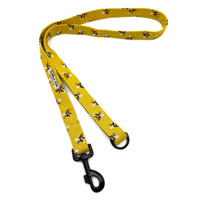 Yellow dog leash with bee pattern on a white background