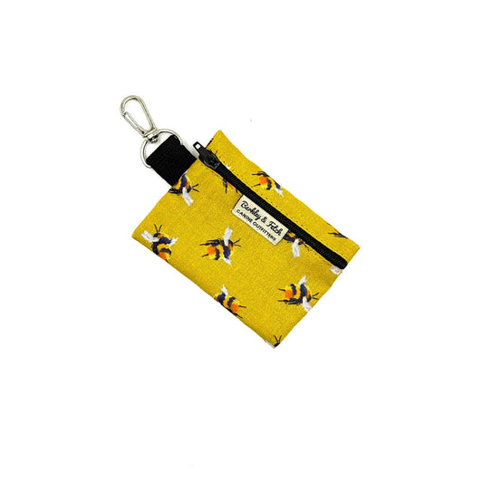 Yellow fabric key fob with bee pattern on a white background