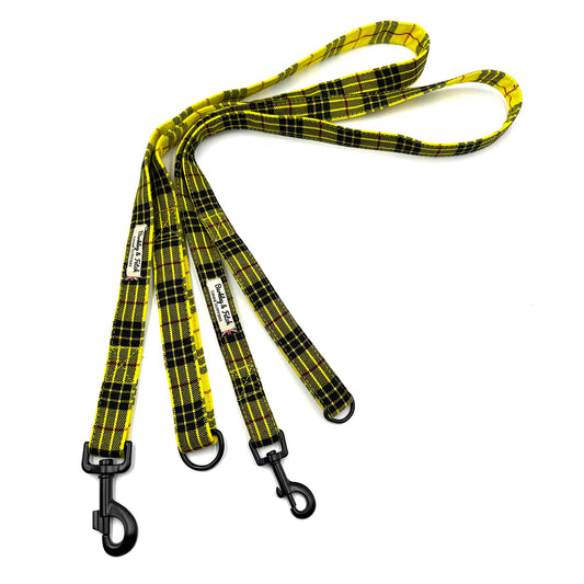 Yellow and black plaid dog leash with black clips on a white background