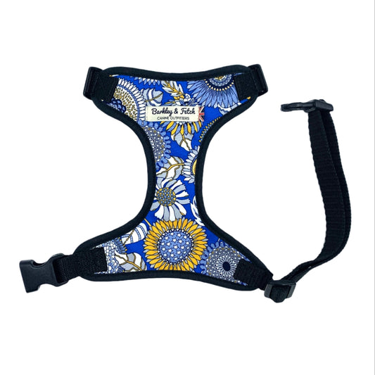 A floral patterned dog harness with adjustable straps and a side release buckle.