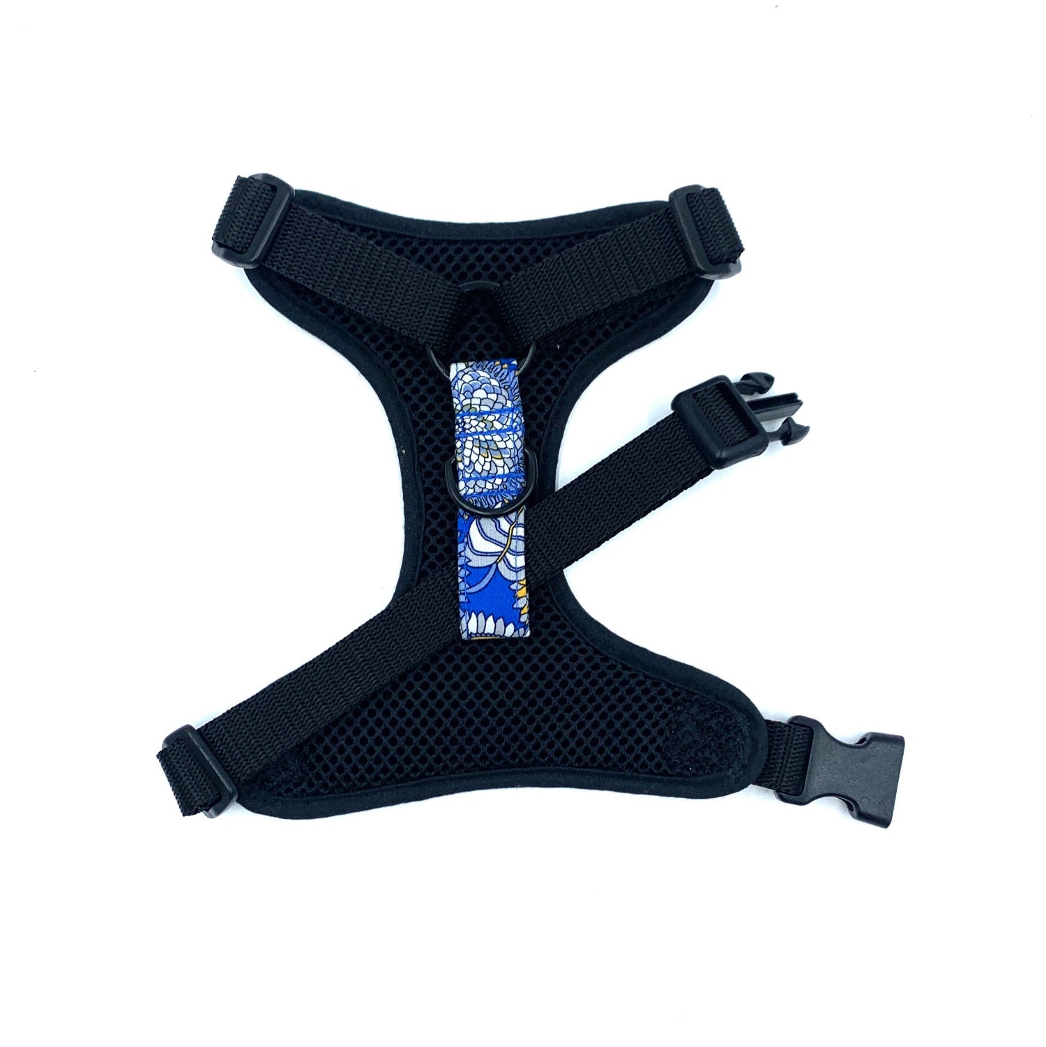 Black dog harness with a blue and white patterned patch on a white background