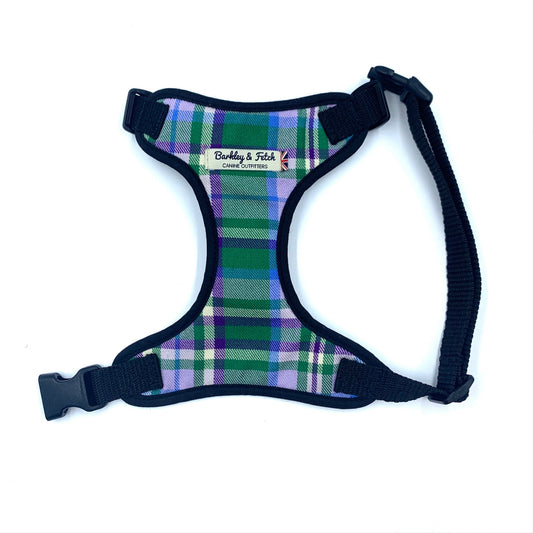 A plaid pattern dog harness in green and purple with black straps and a side release buckle.