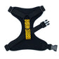 Black dog harness with a yellow leopard print strap on a white background