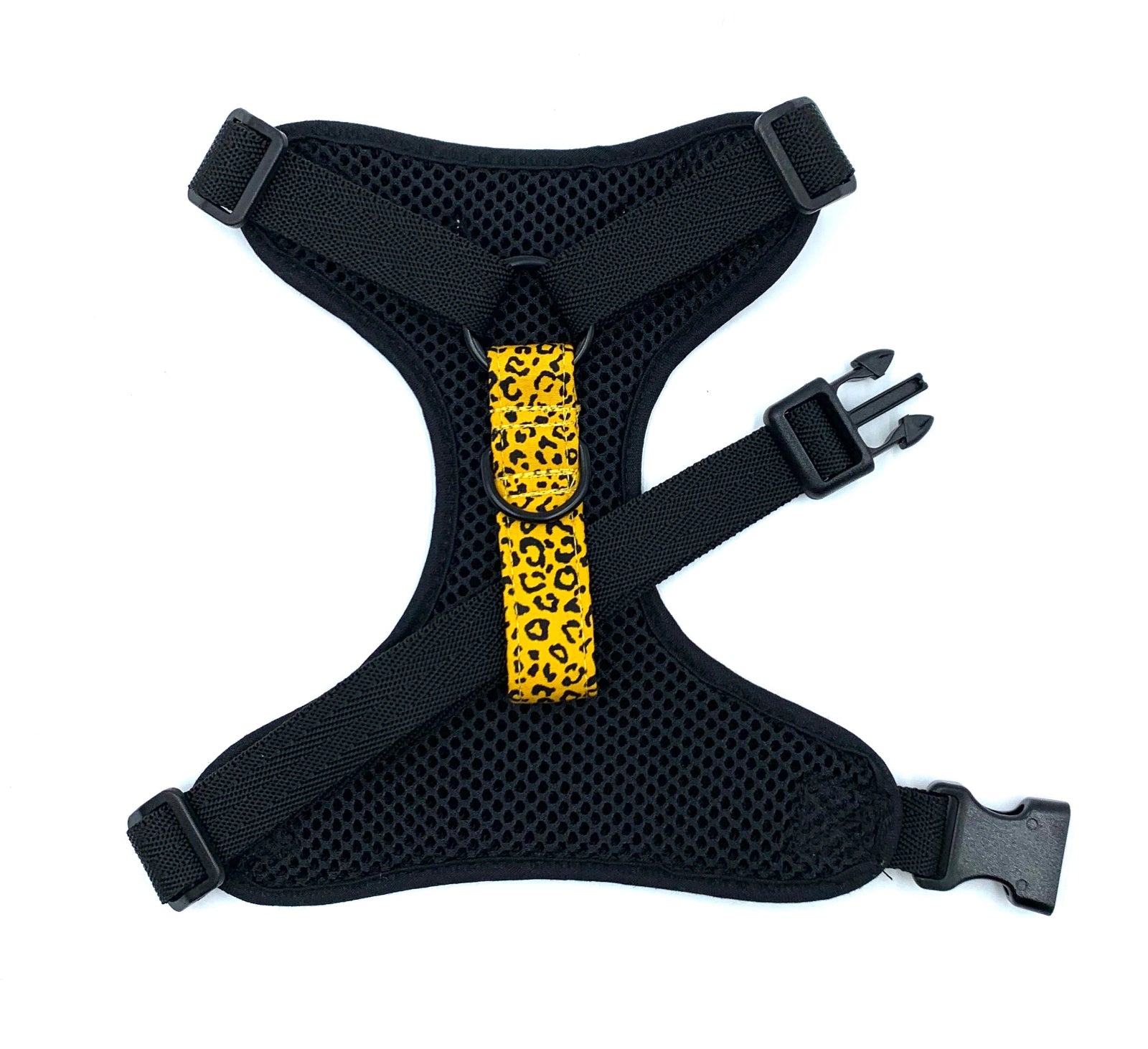 Black dog harness with a yellow leopard print strap on a white background