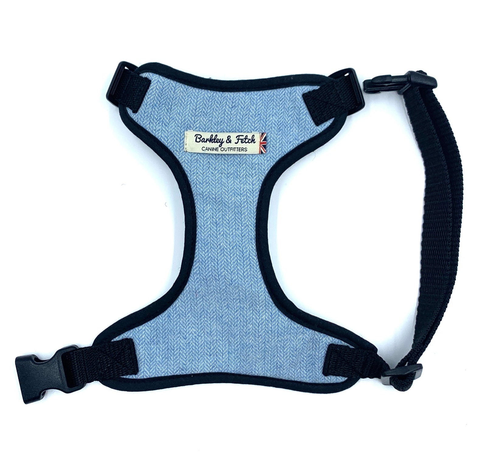 A pale blue wool herringbone fabric dog harness with adjustable straps, padded mesh, and a heavy duty d-ring. The harness is designed to slip over the dog's head and has a side release buckle.