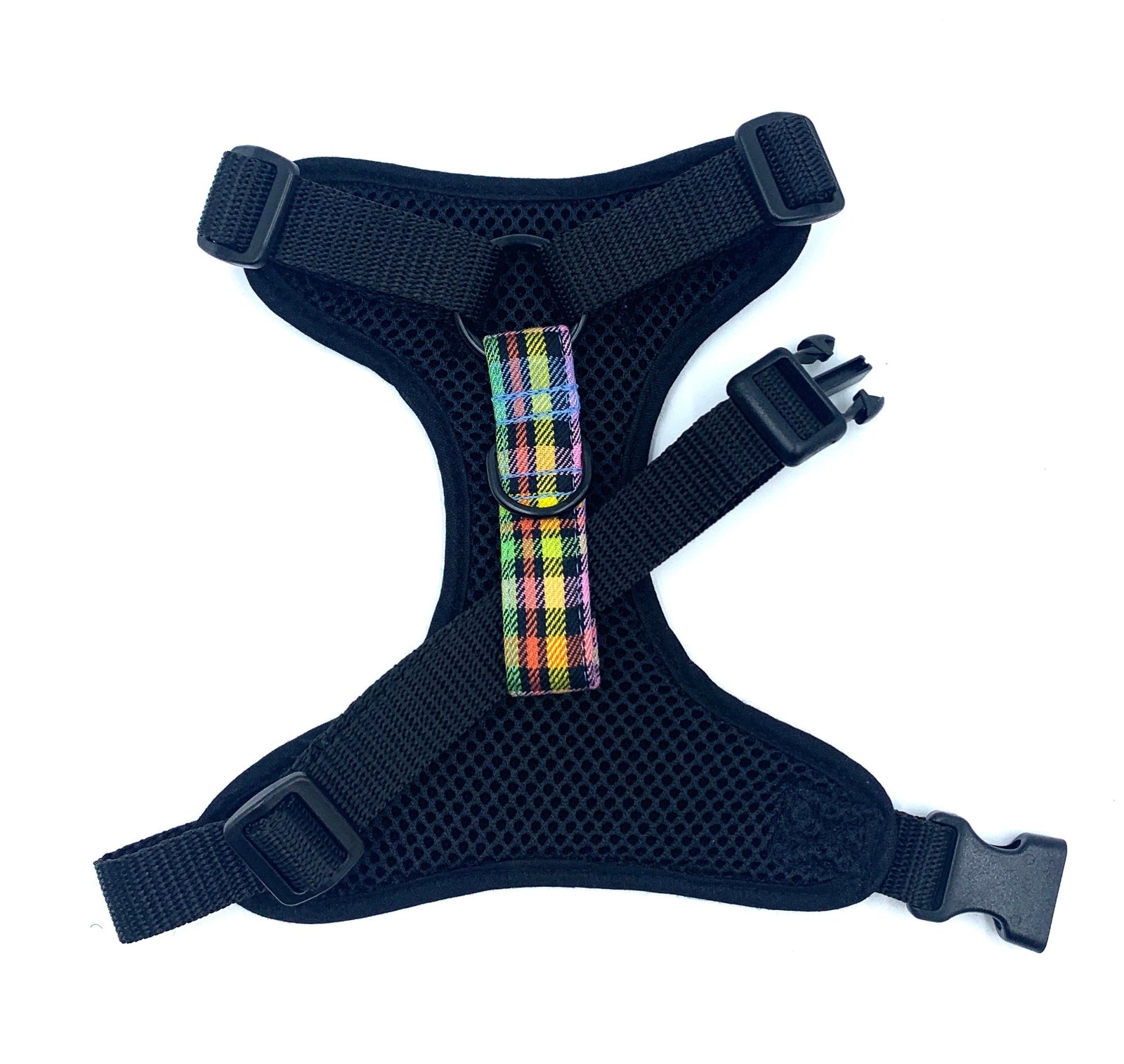 Black dog harness with a colorful plaid patch on a white background