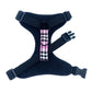 Black dog harness with a pink plaid bow on a white background