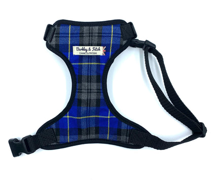 A dog harness with a royal blue tartan pattern, black trim, and adjustable straps, featuring a side release buckle and a heavy duty d-ring.