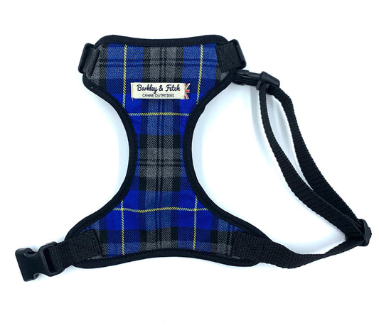 A dog harness with a royal blue tartan pattern, black trim, and adjustable straps, featuring a side release buckle and a heavy duty d-ring.