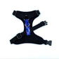 Black dog harness with a purple and blue patterned strap on a white background