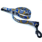 A dog leash with a floral burst print in blue and yellow, featuring a metal trigger hook and a D-ring on the handle.