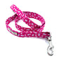A hot pink floral print dog lead with a metal trigger hook and a D-ring on the handle.