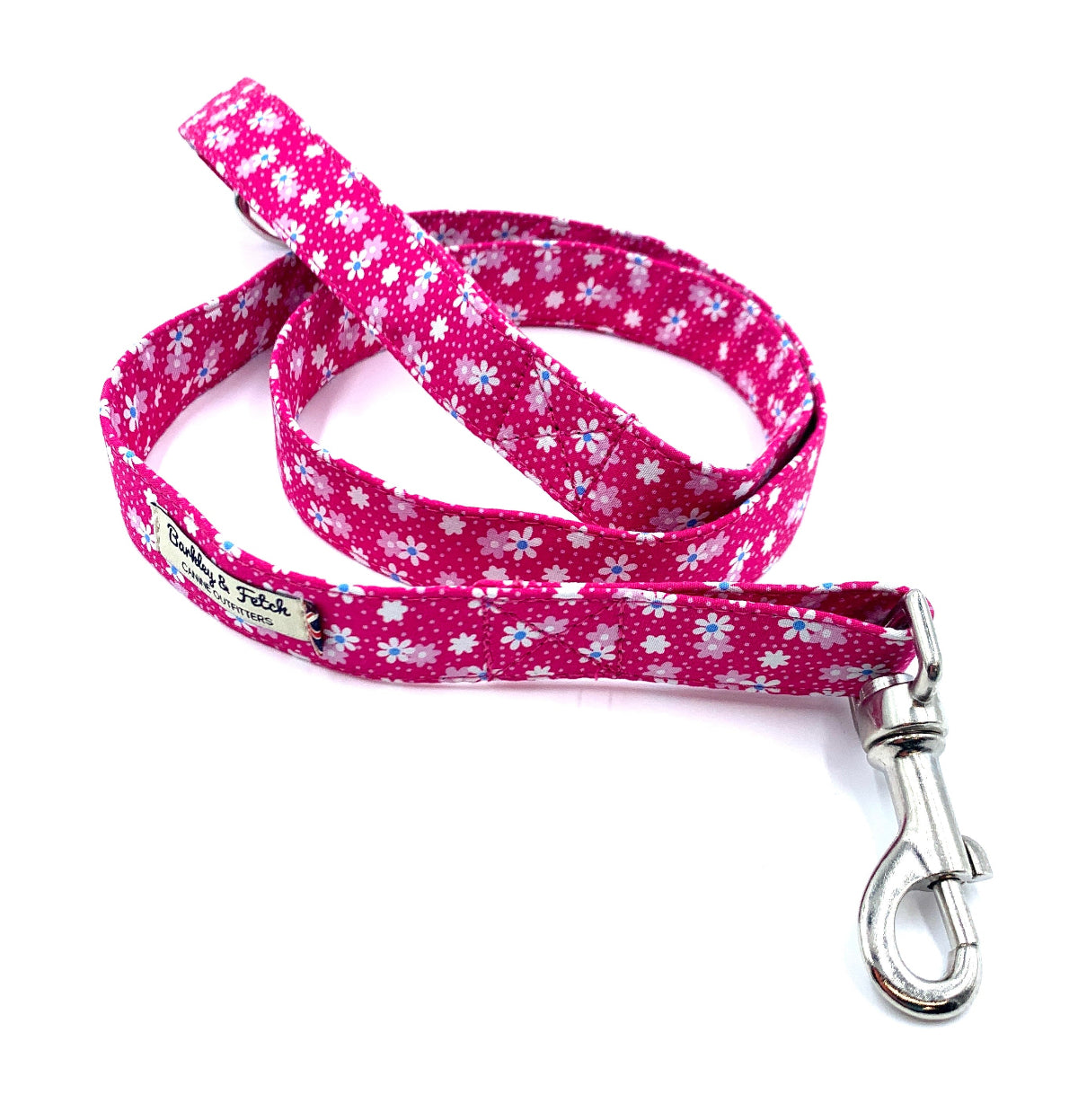 A hot pink floral print dog lead with a metal trigger hook and a D-ring on the handle.