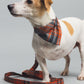 Dog wearing a plaid bandana with matching leash on a gray background