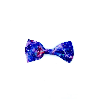 A dog bowtie with a space odyssey print, featuring a black background with stars and planets.